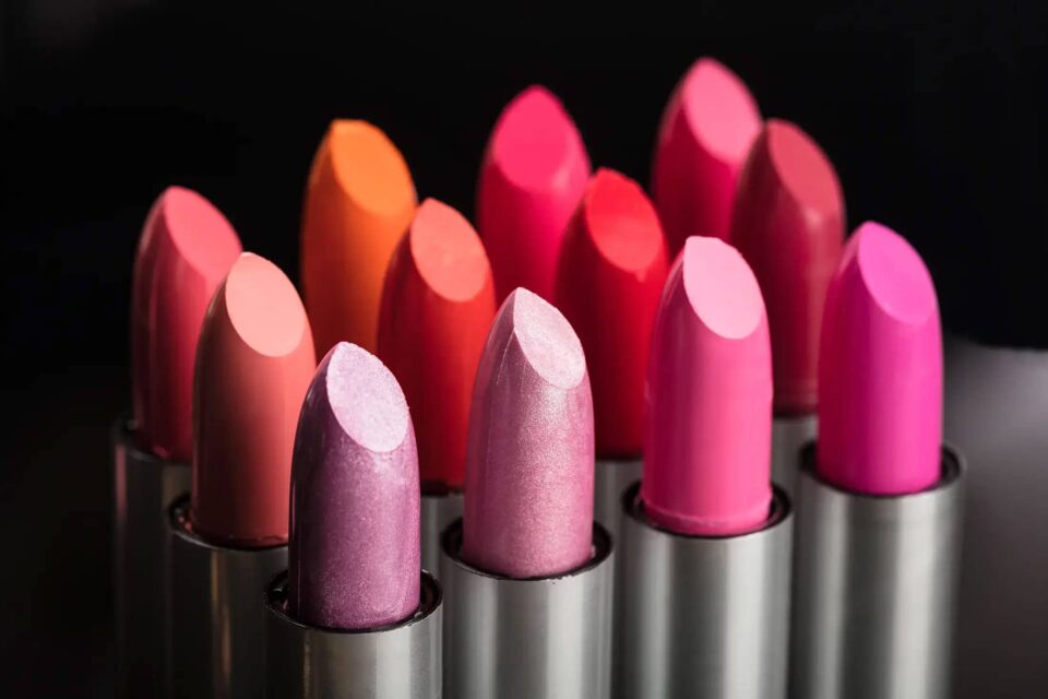 Kosmetik: Nachweis von Poreneinschlüssen in Lippenstiften - verschiedene rosa und rote Lippenstifte mit schwarzem Hintergrund, einige davon mit Metallic-Effekt